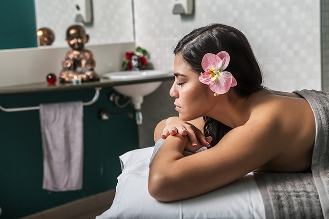 Sensual woman with flower in hair on table